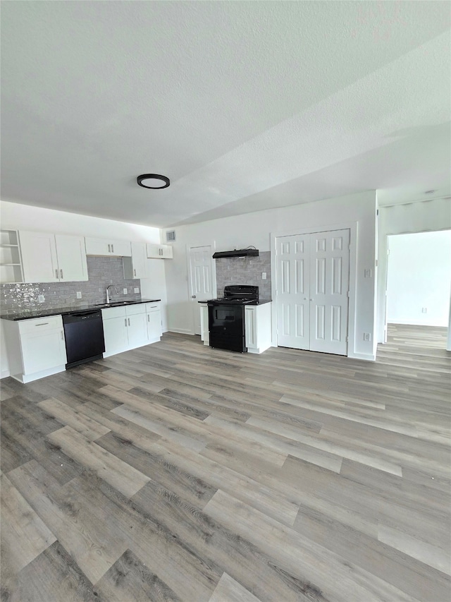 kitchen featuring black appliances, sink, light wood-type flooring, tasteful backsplash, and white cabinetry