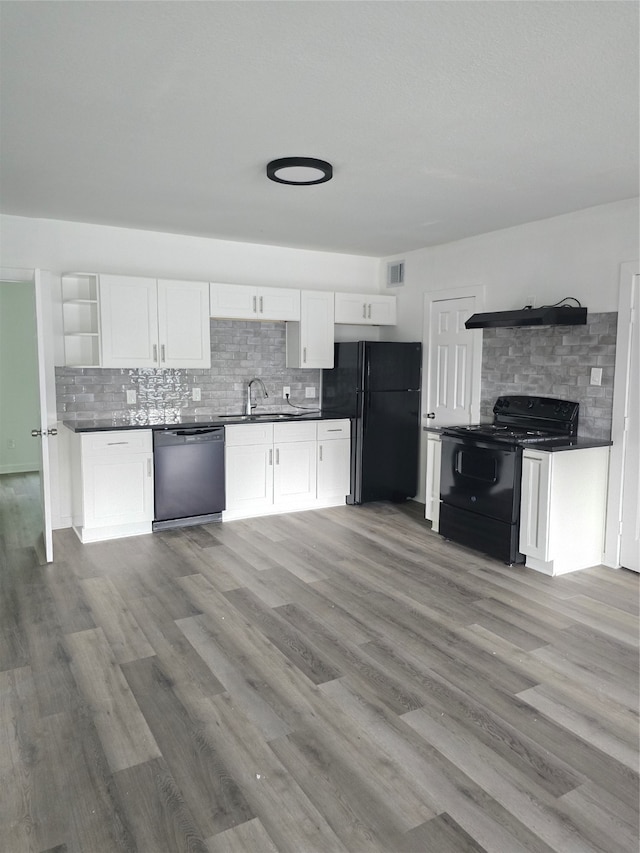 kitchen featuring sink, backsplash, hardwood / wood-style floors, white cabinets, and black appliances