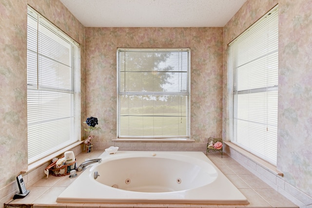 bathroom featuring a textured ceiling, tiled bath, and plenty of natural light