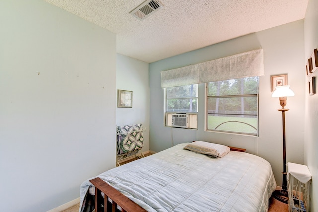 carpeted bedroom with cooling unit and a textured ceiling