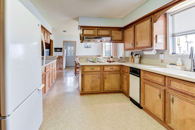 kitchen featuring kitchen peninsula, sink, white fridge, and a textured ceiling