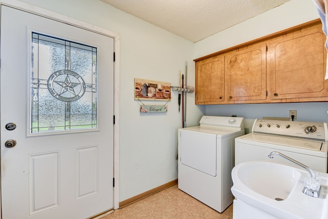 clothes washing area with plenty of natural light, sink, a textured ceiling, and washing machine and clothes dryer