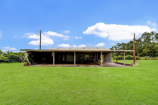 rear view of property featuring an outbuilding and a yard