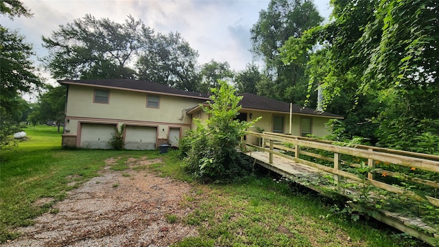 back of house featuring a garage and a lawn