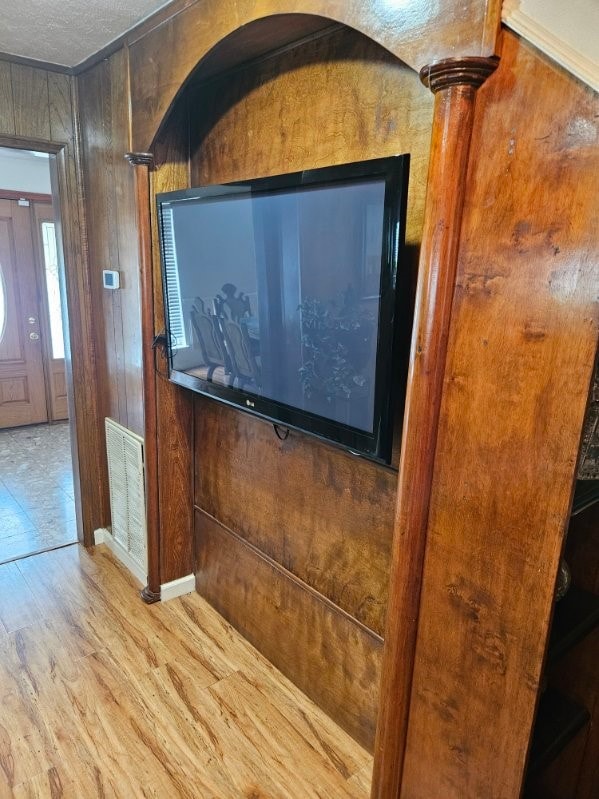 details featuring hardwood / wood-style flooring, wood walls, and ornate columns