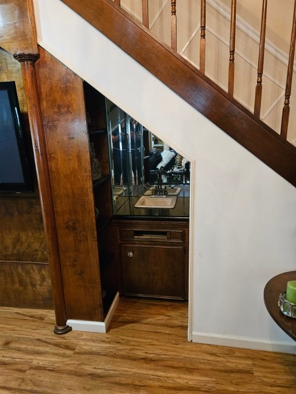 bar featuring dark brown cabinetry, hardwood / wood-style flooring, and sink