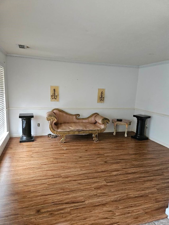 sitting room with hardwood / wood-style flooring and ornamental molding