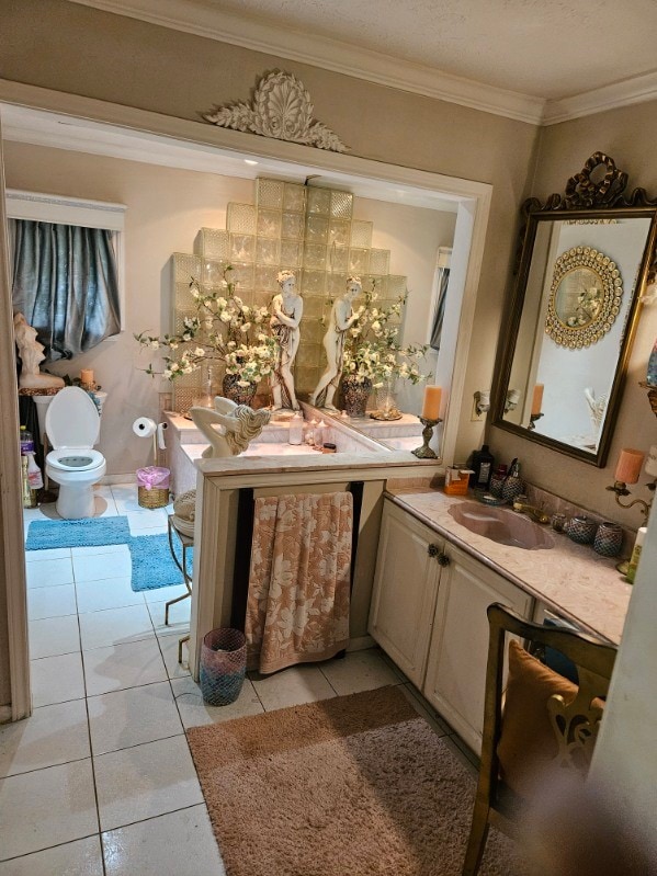 bathroom with tile patterned flooring, toilet, and crown molding