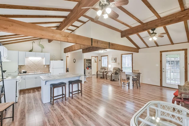 kitchen featuring plenty of natural light, white cabinets, white appliances, and light hardwood / wood-style flooring