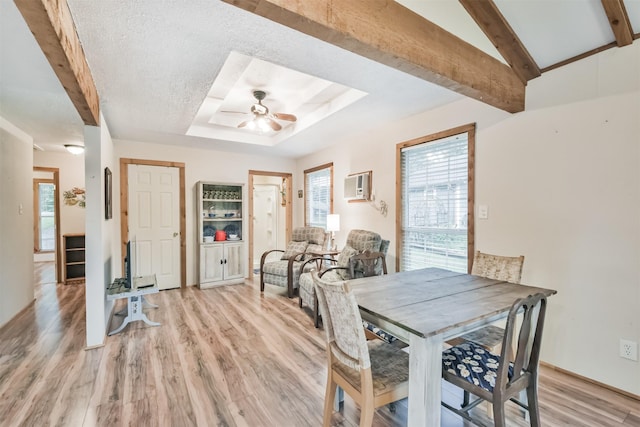 dining room featuring a wall mounted AC, vaulted ceiling with beams, light hardwood / wood-style flooring, and ceiling fan