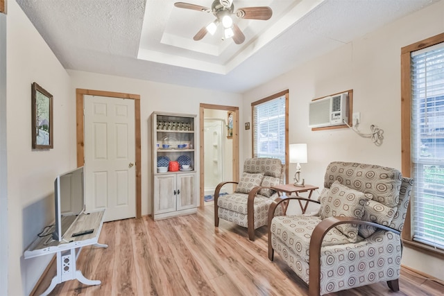 sitting room with plenty of natural light, light hardwood / wood-style floors, and ceiling fan