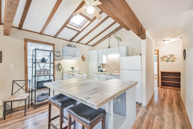 kitchen featuring white cabinets, light wood-type flooring, white appliances, and a breakfast bar