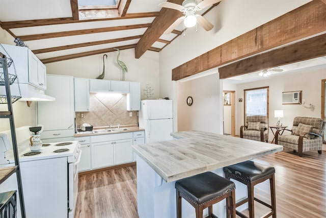 kitchen with a breakfast bar, white appliances, white cabinets, sink, and light hardwood / wood-style floors