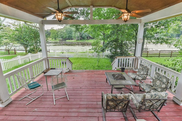 wooden terrace with ceiling fan and a water view