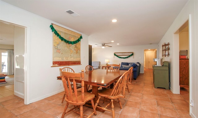 dining space featuring ceiling fan, crown molding, and light tile patterned flooring