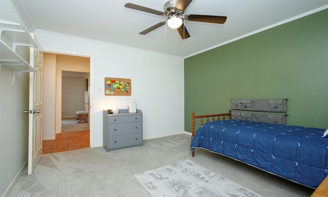 carpeted bedroom featuring ceiling fan and crown molding