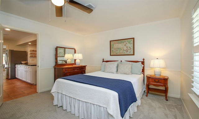 carpeted bedroom with stainless steel fridge, ceiling fan, ensuite bath, and ornamental molding