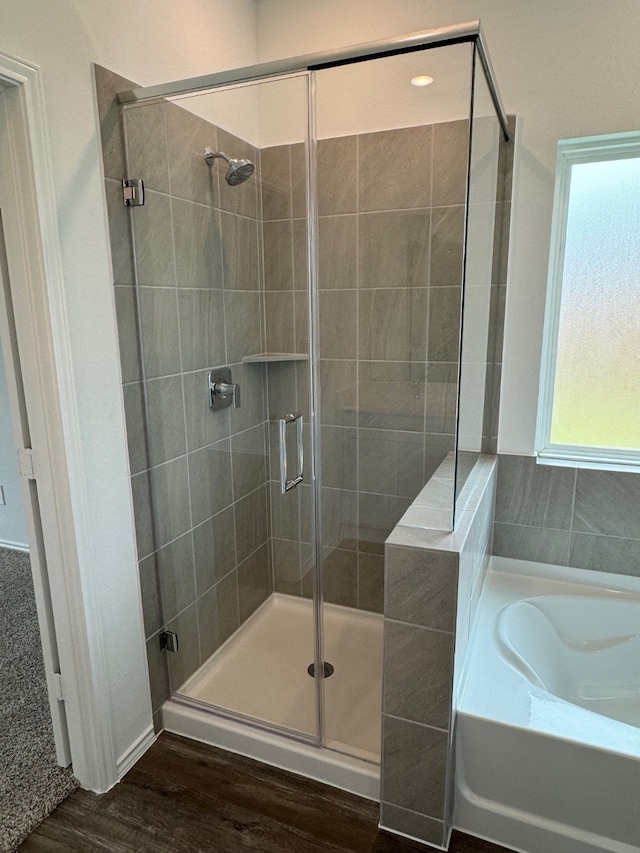 bathroom featuring independent shower and bath and hardwood / wood-style floors