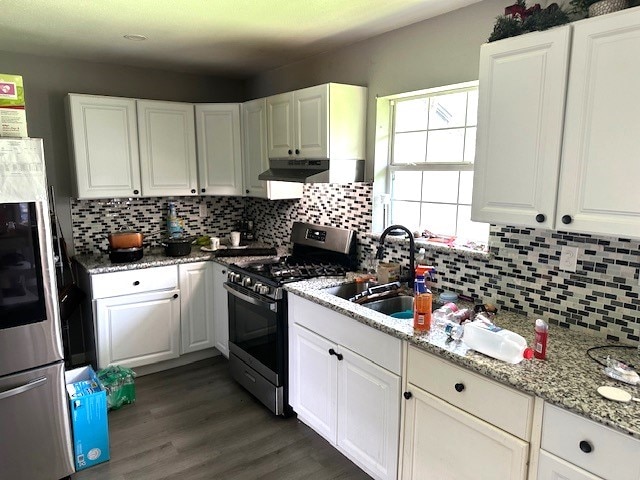 kitchen featuring light stone countertops, sink, dark hardwood / wood-style flooring, white cabinets, and appliances with stainless steel finishes