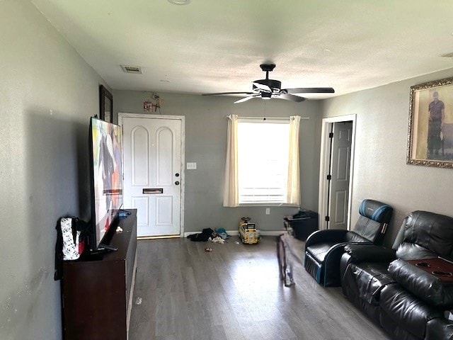 living room featuring wood-type flooring and ceiling fan