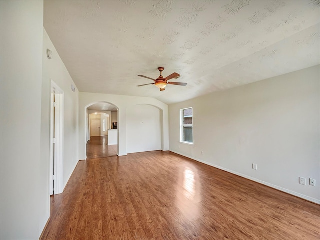 unfurnished living room with ceiling fan, wood-type flooring, and a textured ceiling