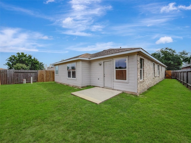 rear view of house with a lawn and a patio area