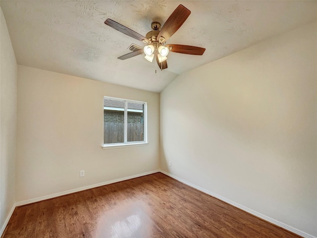 spare room featuring ceiling fan, lofted ceiling, and hardwood / wood-style flooring