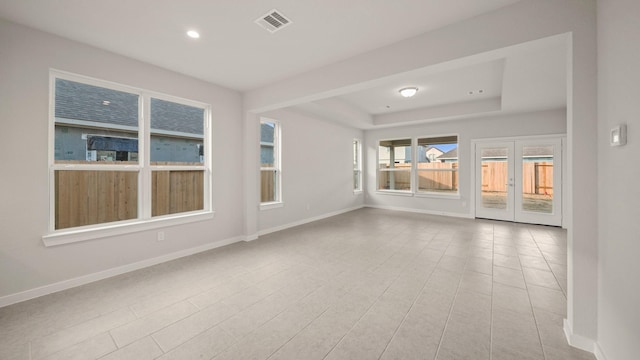 tiled spare room featuring french doors