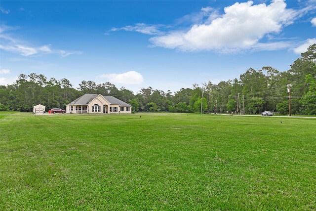 view of yard featuring an outdoor structure and a wooded view