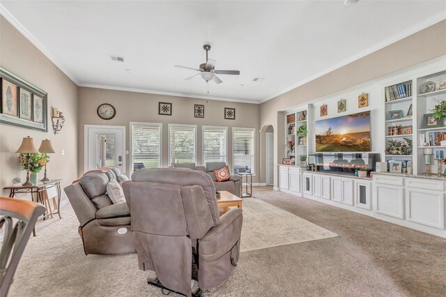 living room featuring visible vents, ornamental molding, arched walkways, and light colored carpet