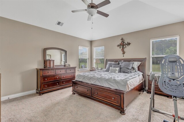 bedroom featuring light carpet, baseboards, visible vents, a ceiling fan, and vaulted ceiling