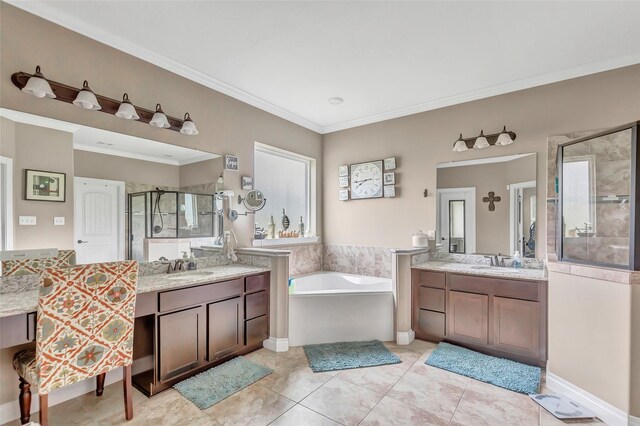 full bath with a garden tub, crown molding, two vanities, a sink, and a shower stall