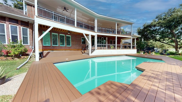 view of pool featuring ceiling fan and a deck