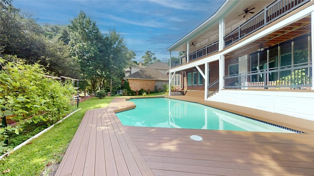 view of swimming pool with ceiling fan and a wooden deck