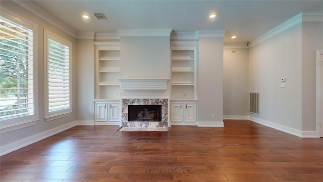 unfurnished living room featuring a high end fireplace, dark wood-type flooring, plenty of natural light, and crown molding