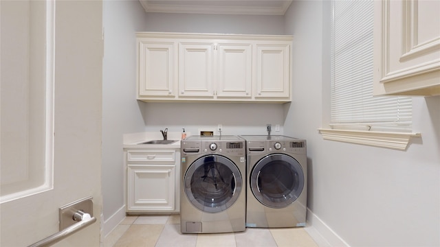 laundry room featuring cabinets, crown molding, sink, light tile patterned floors, and washing machine and dryer