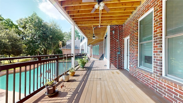 deck with ceiling fan and a swimming pool