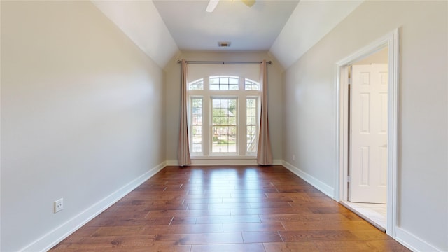 doorway with ceiling fan, dark hardwood / wood-style flooring, and lofted ceiling