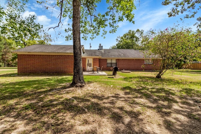 back of property with a yard and a patio