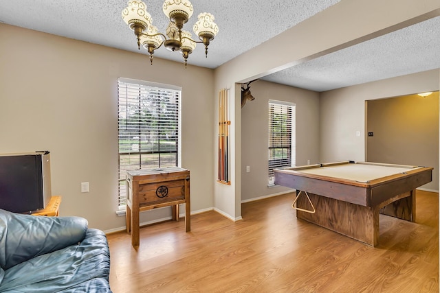 game room featuring plenty of natural light, a textured ceiling, billiards, and light hardwood / wood-style flooring