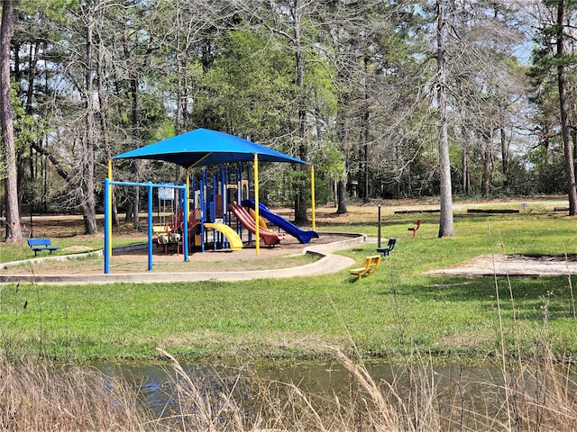 view of jungle gym with a lawn and a water view