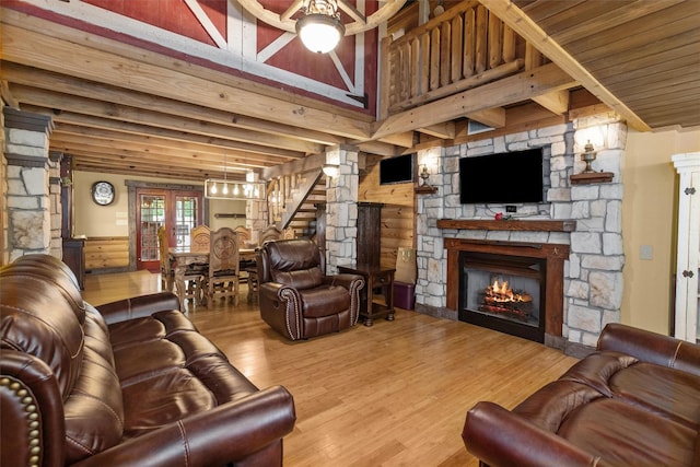 living room featuring light hardwood / wood-style flooring, a fireplace, french doors, and log walls