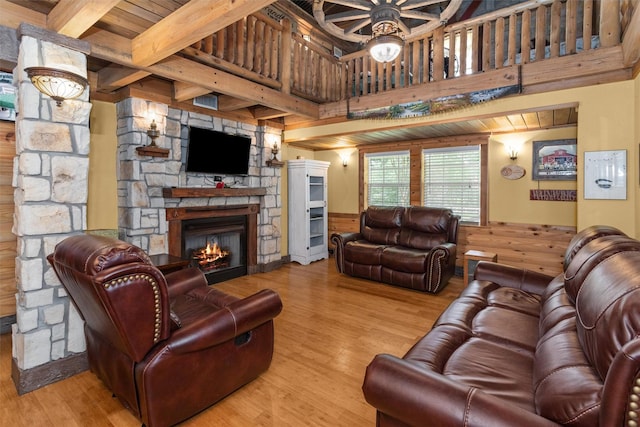 living room with ceiling fan, light wood-type flooring, and a fireplace