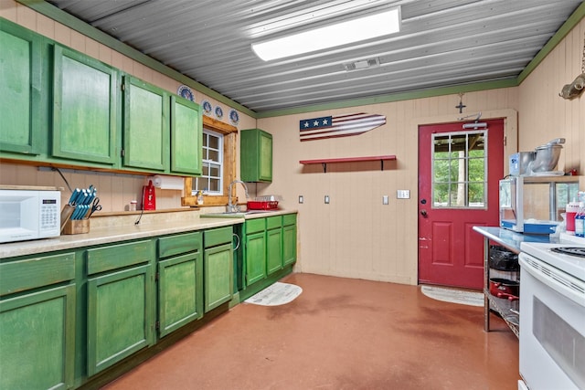 kitchen with white appliances, sink, green cabinetry, and concrete flooring