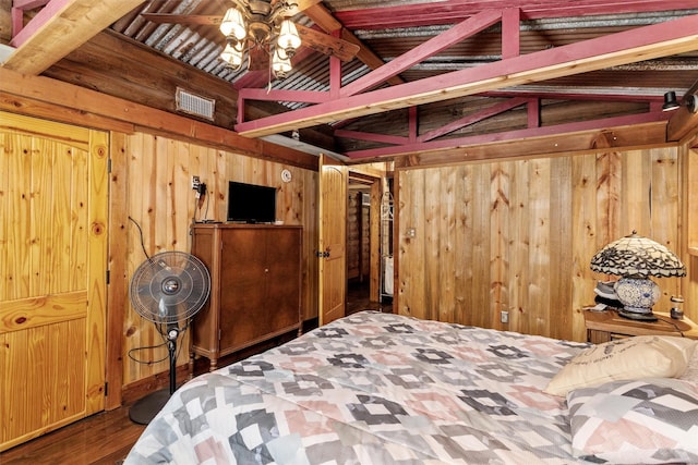 bedroom featuring wooden walls, vaulted ceiling with beams, and hardwood / wood-style floors