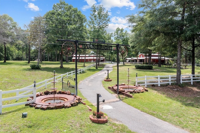 view of property's community with a yard and a fire pit