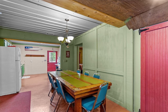 carpeted dining area with a chandelier