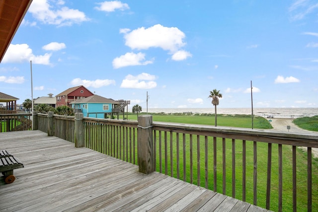 wooden terrace featuring a water view and a yard