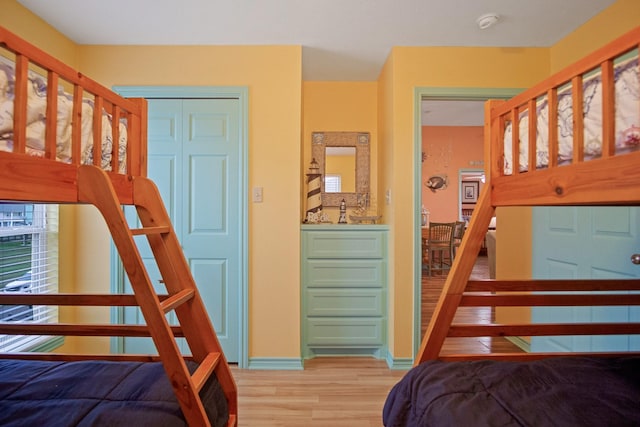 bedroom with light hardwood / wood-style floors and a closet