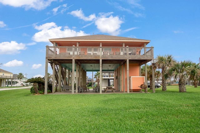 rear view of property featuring a wooden deck and a lawn